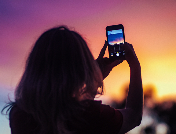 someone taking a photo of the sunset