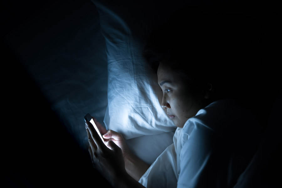 Persona viendo su pantalla de celular en la noche