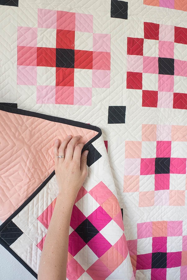 Hand touching quilt with flower pattern.