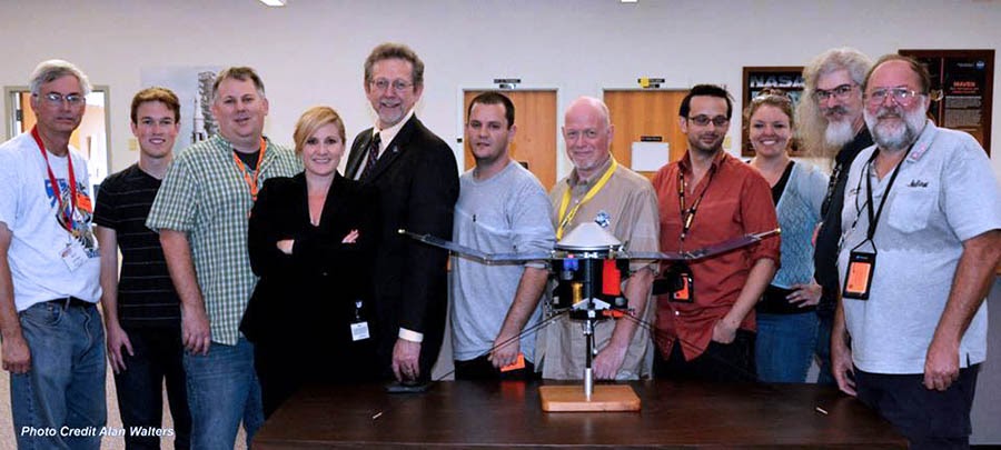 Miembros de RocketSTEM posan con el Dr. Jim Green, Director de Ciencia Planetaria de la NASA (en ese momento), y la nave espacial MAVEN en el Centro Espacial Kennedy.