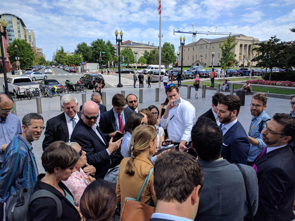 A crowd gathers around the outside of the Washington D.C. courthouse