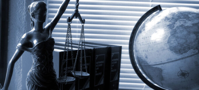 A blindfolded lady justice figurine holds a scale